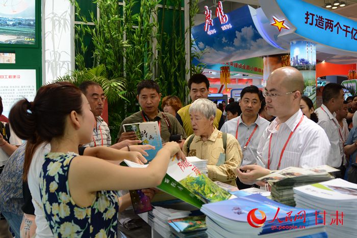 市民在兰洽会陇南展馆参观及翻看资料