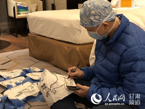 甘肅省支援湖北第三醫療隊隊員正在手工袋上繪圖。（甘肅省衛健委供圖）