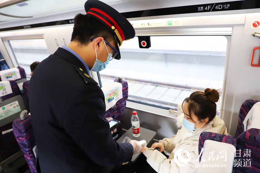 1月27日，由蘭州西開往烏魯木齊的D2711次列車上，列車員正在對旅客進行體溫監測。人民網 王文嘉攝