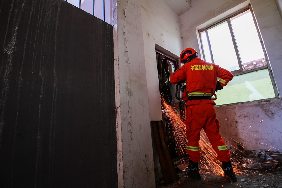 森林消防指战员在演练中破拆铁门。（张小军摄）