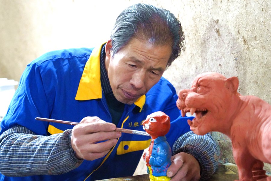民間泥塑藝人劉泉在為萌萌“福虎”著色。郭惠民攝