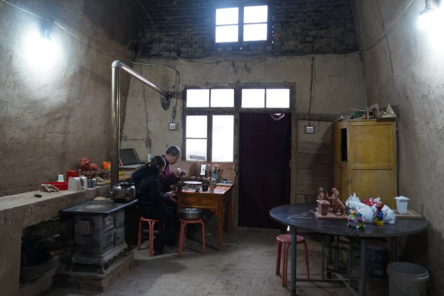 民間泥塑藝人劉泉和妻子在窯洞工作台做泥塑。郭惠民攝