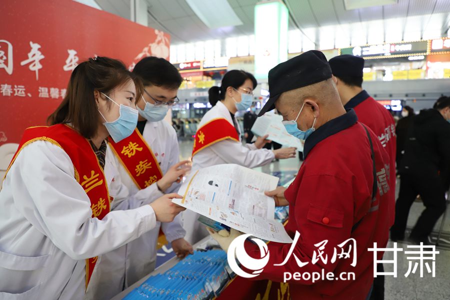 車站工作人員為旅客講解疫情防控知識。人民網 黃帆攝