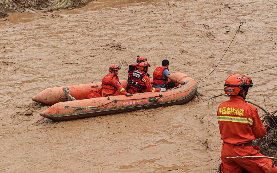 消防救援人员在庆城县翟家河乡转移受灾群众。甘肃省森林消防总队供图