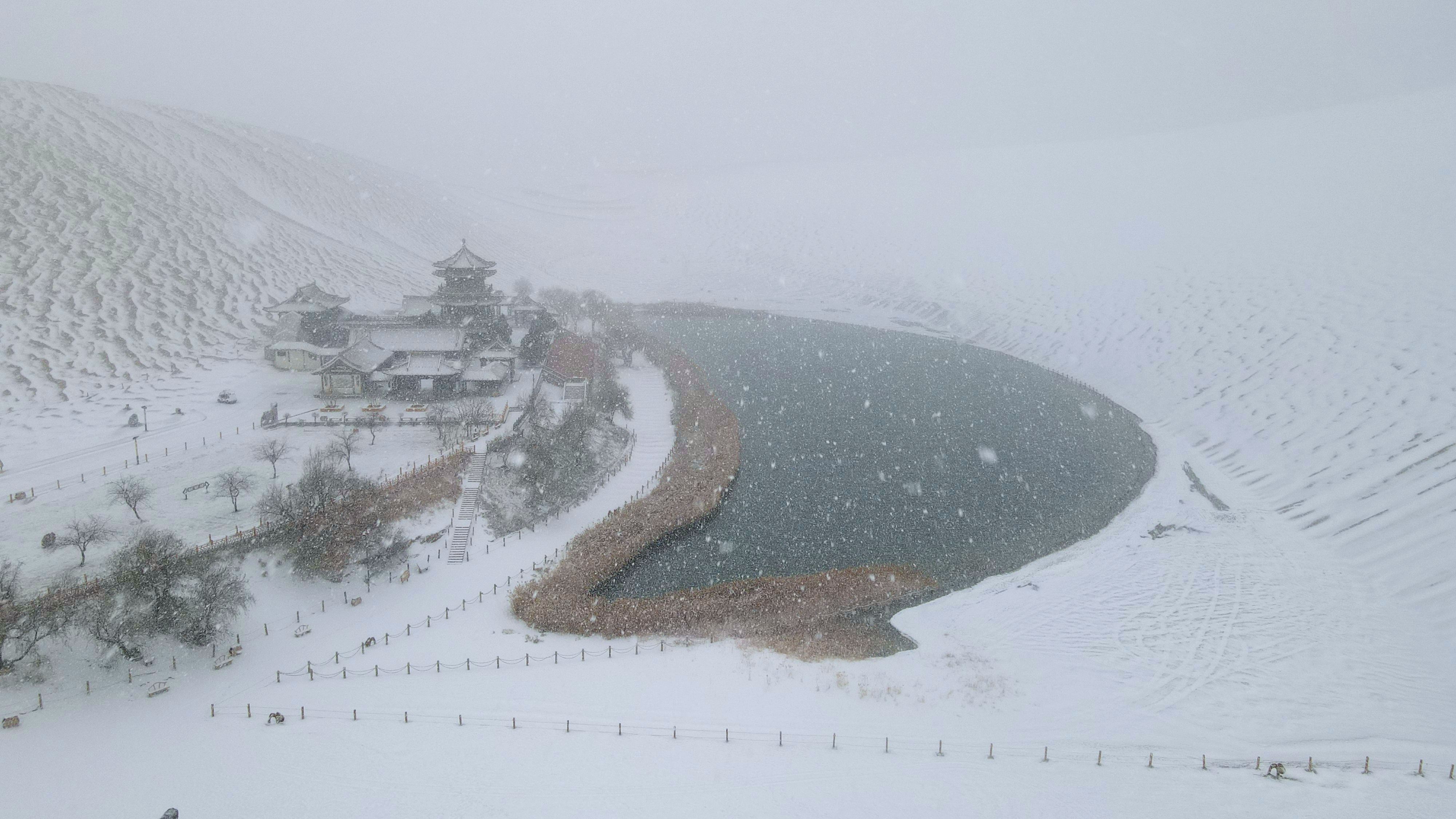 2022年11月27日拍攝的甘肅省敦煌市鳴沙山月牙泉景區雪景（無人機照片）。張曉亮攝