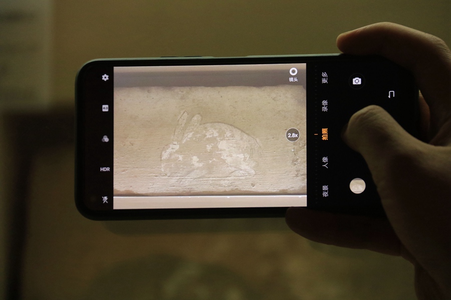 游客手机拍摄魏晋“白兔画像砖”。张晓亮摄
