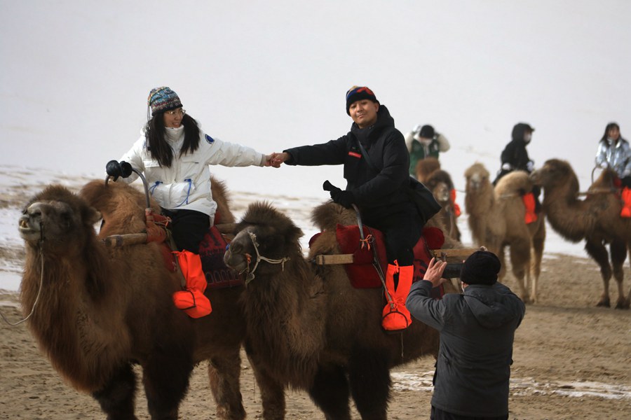 游客在甘肅省敦煌市鳴沙山月牙泉景區游覽。張曉亮攝