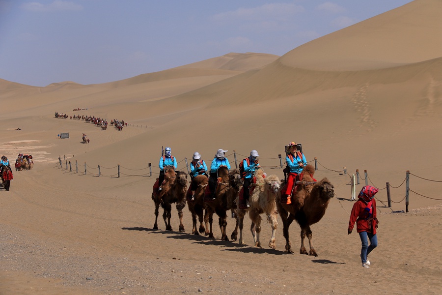 2023年5月11日，游客在甘肅省敦煌市鳴沙山月牙泉景區游覽。張曉亮攝