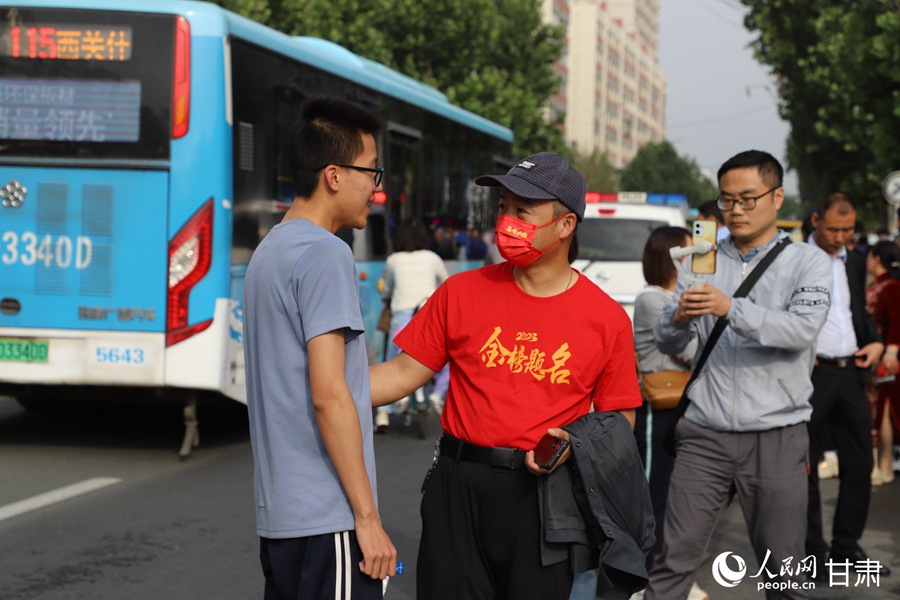 家长送考生进入考场。人民网记者 黄帆摄