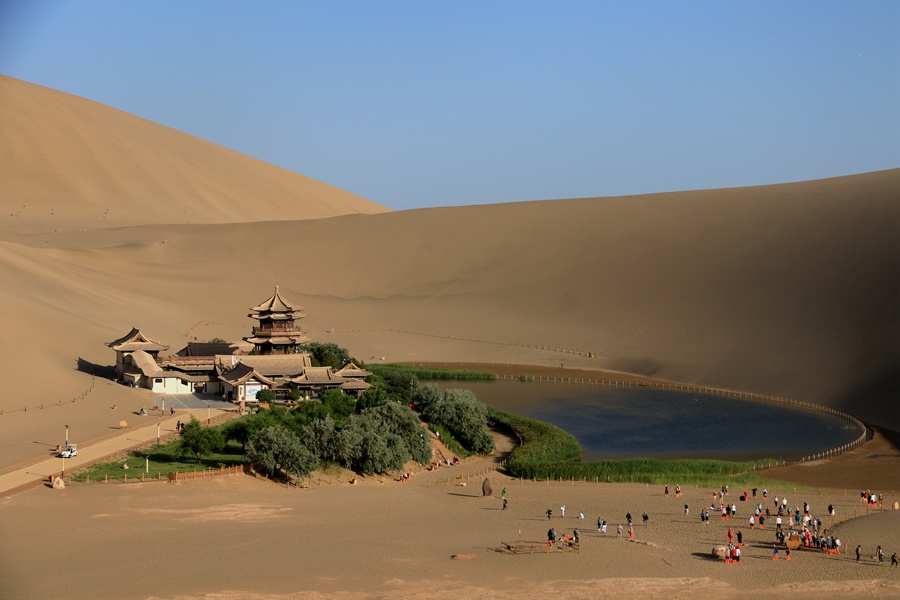 端午假期，游客在甘肅省敦煌市鳴沙山月牙泉景區游覽。張曉亮攝