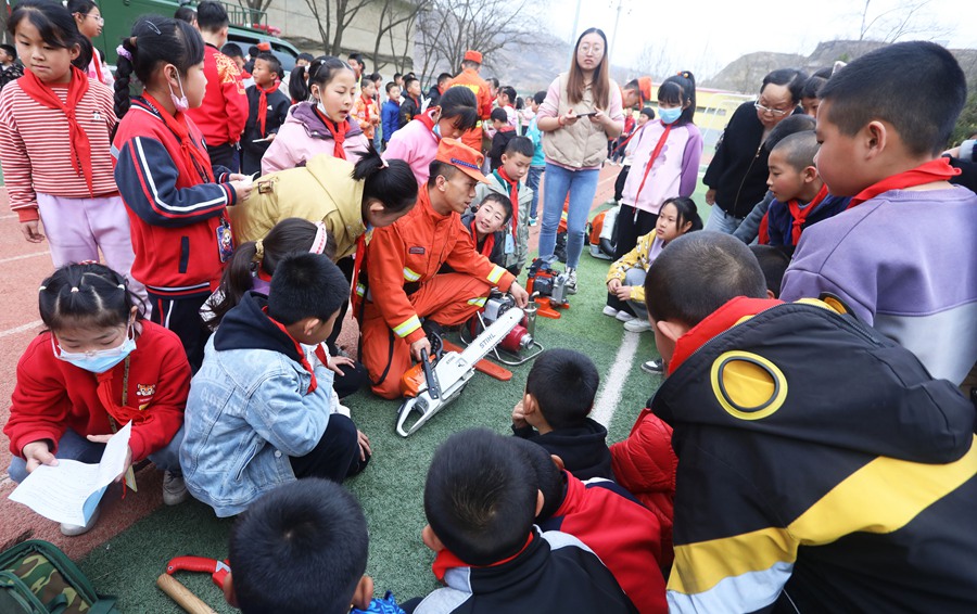 森林消防隊員在七裡河區二十裡鋪鎮中心小學向師生展示滅火裝備。裴海博攝