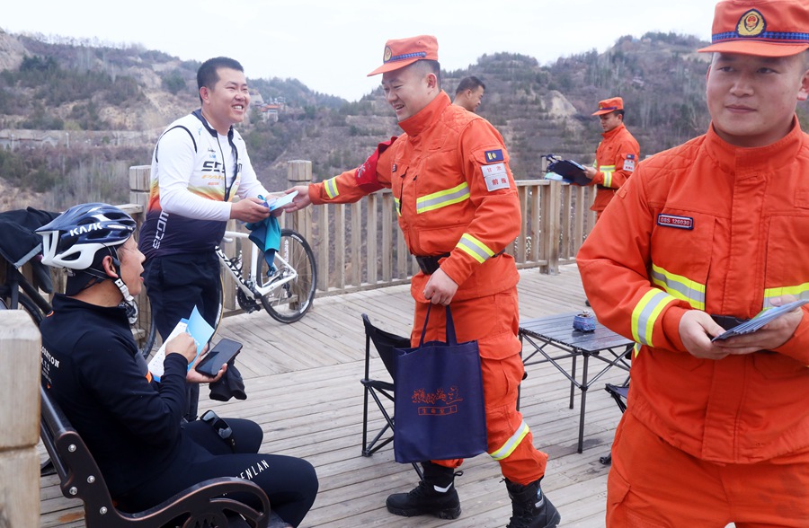 森林消防队员在石佛沟景区向群众发放森林防火宣传手册。裴海博摄
