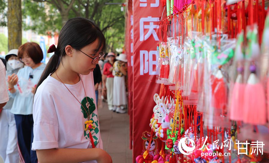 在庆阳民俗文化普品展销区，色彩艳丽、做工精湛的香包吸引了众多市民游客驻足。人民网记者 邵兰摄