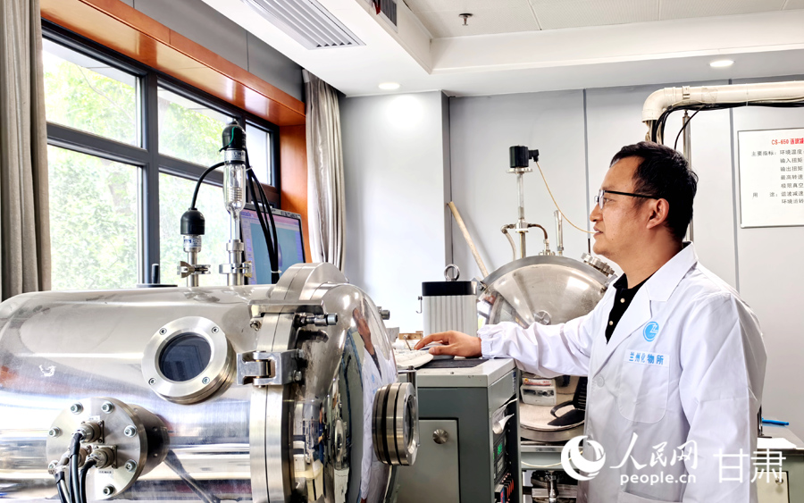 中国科学院兰州化学物理研究所实验室内，研究人员正在查看相关监测数据。人民网记者 高翔摄
