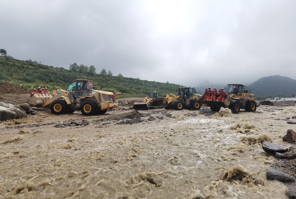 8月9日，甘肅省森林消防總隊在馬坡鄉舊庄溝村沿河道繼續搜尋被困人員，消防員乘載裝載機挺近抗洪搶險一線。張小軍 攝