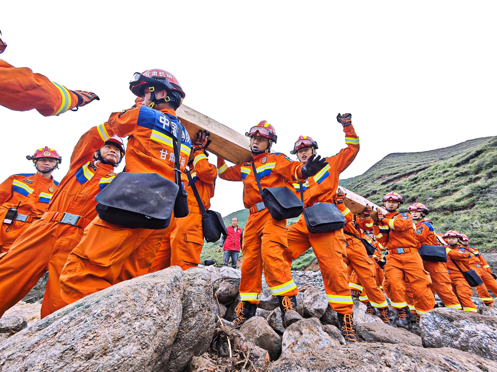 8月9日，甘肃省森林消防总队在马坡乡旧庄沟村沿河道继续搜寻被困人员途中搭建临时木桥。张巍权 摄