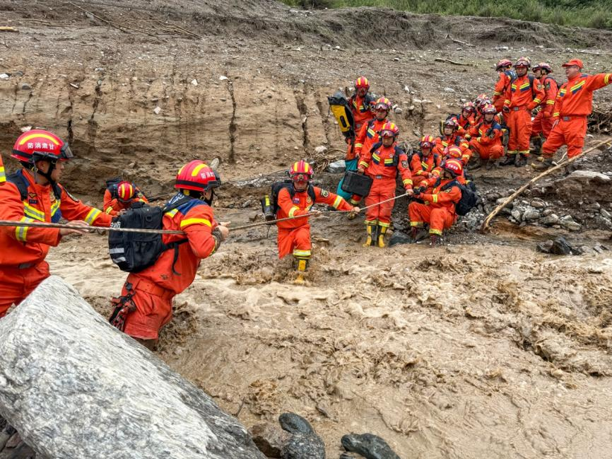 8月8日下午,受强降雨影响,榆中县马莲滩村五社道路损毁严重,消防救援力量正在通过绳索横渡前往救援。甘肃消防供图