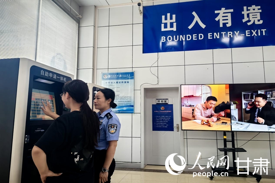 公安民警协助市民填写办理护照所需的个人信息。人民网记者 周婉婷摄