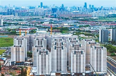 第二十二屆中國國際住宅產業暨建筑工業化產品與設備博覽會上,講解員(右)向觀眾介紹展出的節能建筑。新華社記者 潘 旭攝