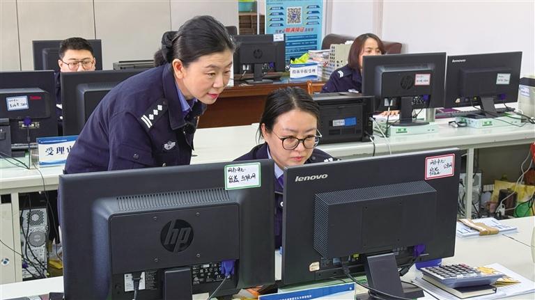 车管所工作人员在协商办理新车上牌业务