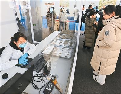 二〇二五年年初，“妙手活千秋——科技考古与遗产保护经典成就展”在位于北京的中国考古博物馆开展。图为参观者在展厅观看实验室考古展示区。新华社记者 李 贺摄