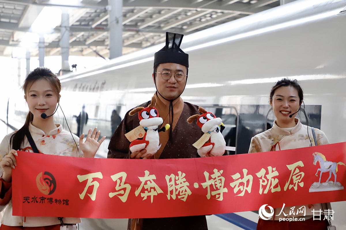 天水市博物馆和甘肃简牍博物馆工作人员迎接旅客乘车。人民网记者 焦隆摄