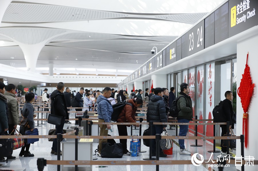 兰州中川国际机场T3航站楼内，旅客有序通过安检通道。人民网记者 焦隆摄