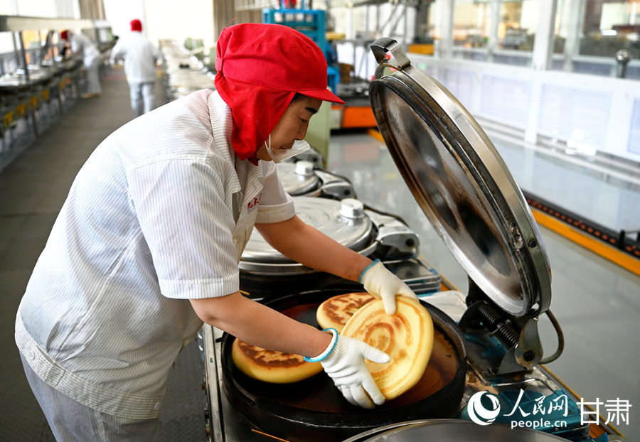 工人为烤炉上的静宁大饼翻面。人民网 席娟娟摄