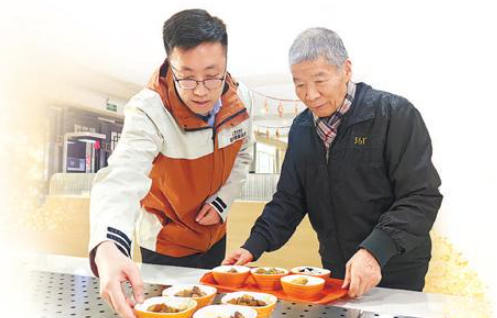 楊俊哲（左）幫老人選擇菜品。本報記者 易舒冉攝