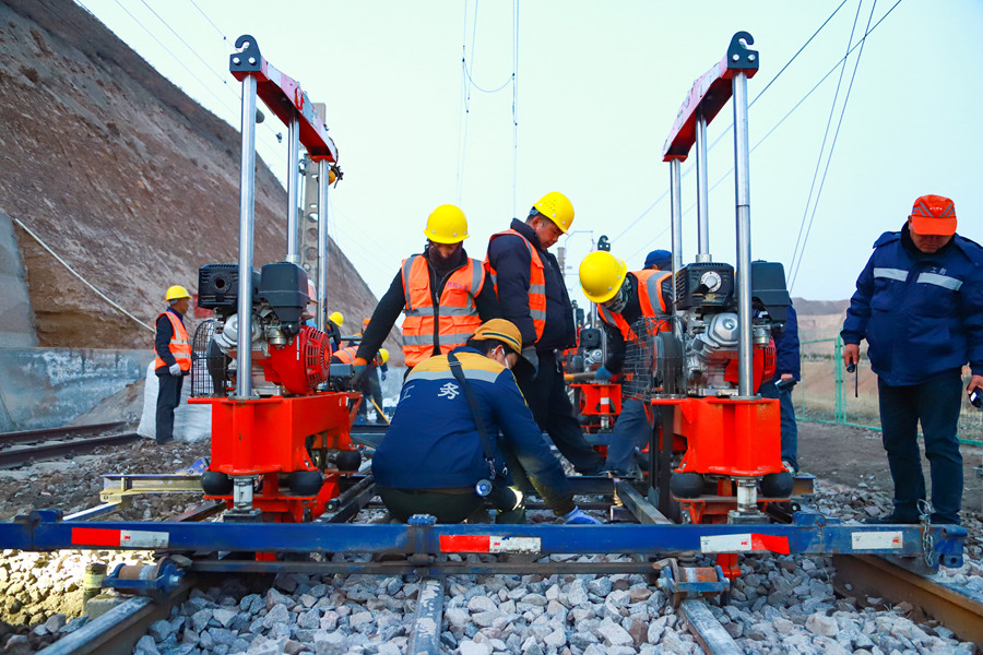 蘭州西工務段職工在包蘭線水源站對清篩后的道岔進行人工搗固作業。王光輝攝