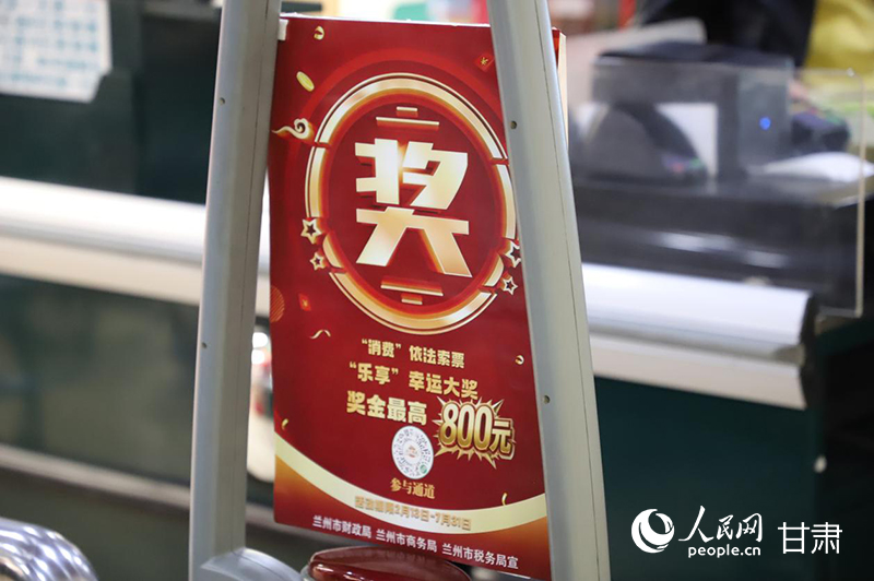 超市收银台前，“小兰有礼”活动提示牌引导消费者主动索票。实习生 黄诗语摄
