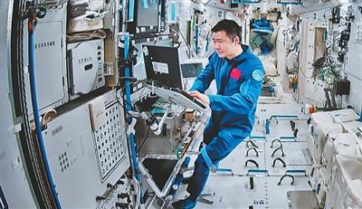 在北京航天飞行控制中心屏幕上拍摄的陈冬在空间站组合体舱内工作画面。新华社记者 李明刚摄
