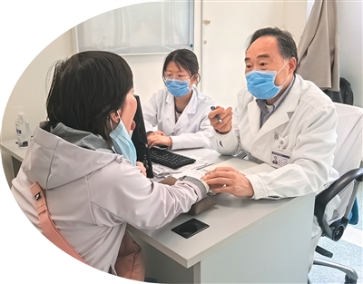 王宪波（右一）正在为一名患者看舌象。本报记者 陈静文摄