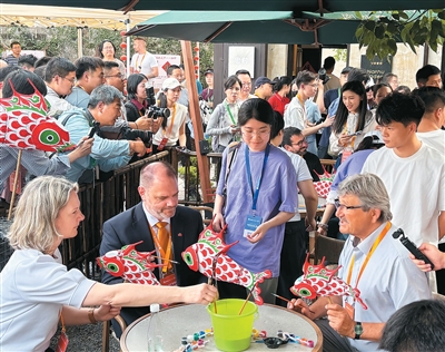 外国市长、代表体验鱼灯制作。