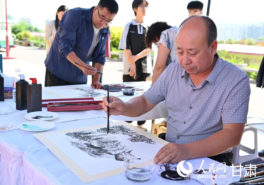 康乐县文联工作人员为群众送上绘画、书法作品。人民网 席娟娟摄