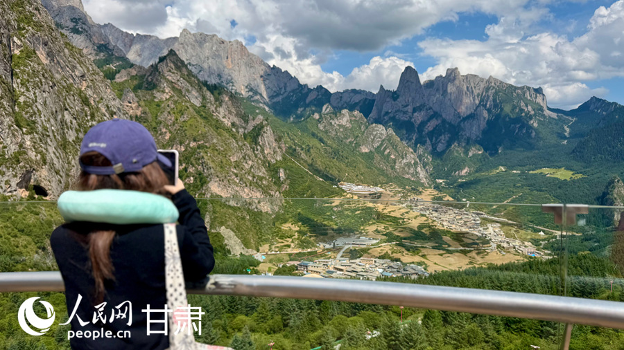游客在扎尕那景区游览拍照，尽享藏乡初秋风光。人民网记者 焦隆摄
