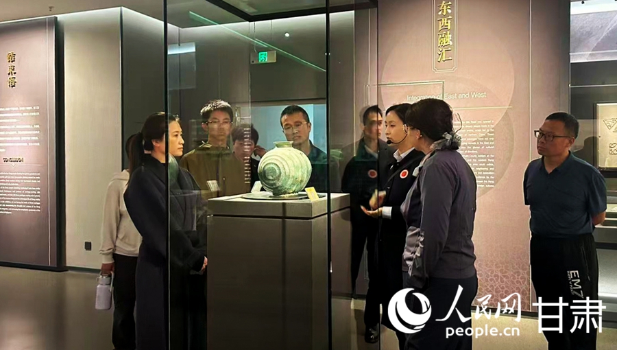 游客驻足展柜前，听讲解员讲述马家塬遗址出土文物背后的故事。人民网记者 米媛摄