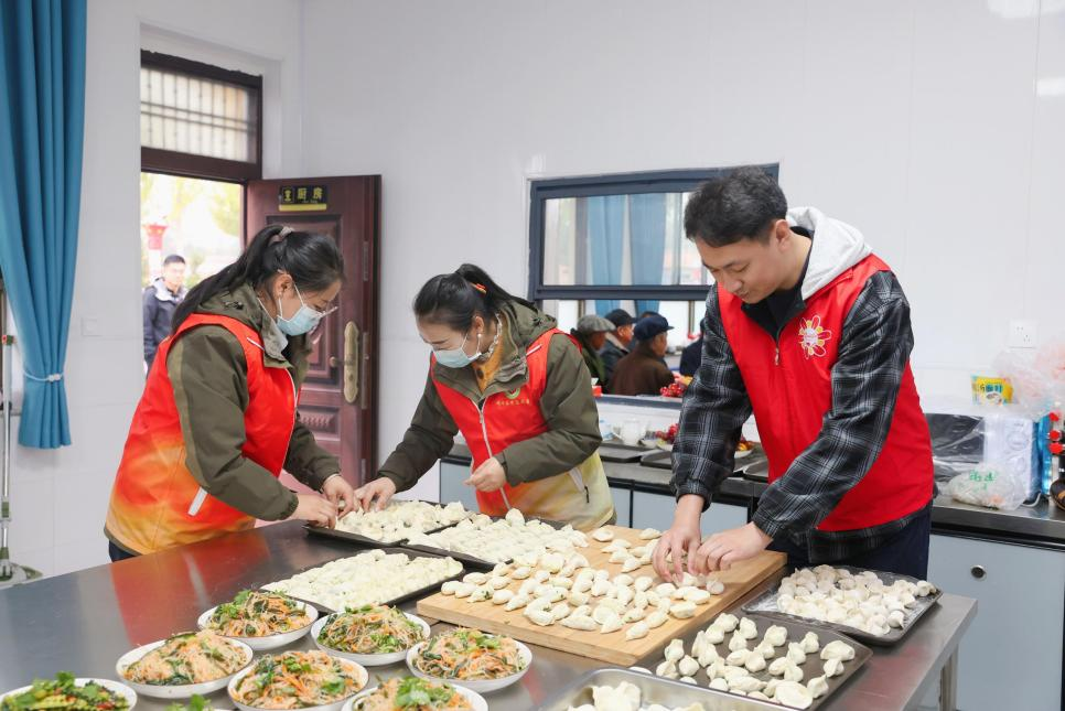 志愿者为老人包饺子。