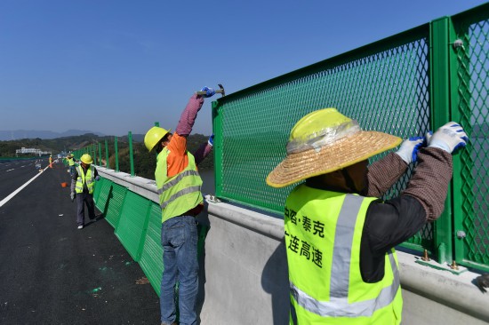 12月19日，施工人员在位于清远英德市的广连高速北江特大桥安装护栏。