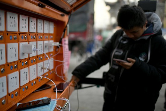 12月20日，在甘肅省臨夏州積石山縣大河家鎮大河村集中安置點，受災群眾正在充電站給手機充電。人民網記者 翁奇羽攝