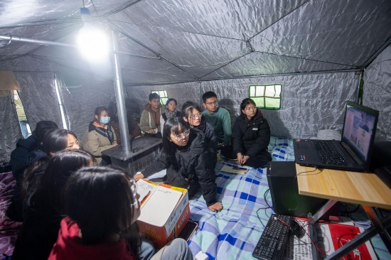 12月22日，在甘肅省臨夏州積石山縣大河家鎮大河村集中安置點，部分高中學生在帳篷中聽課。人民網記者 翁奇羽攝