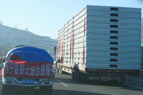 12月24日，行驶在前往青海省海东市民和县的高速公路上的支援物资车。人民网记者 甘海琼摄
